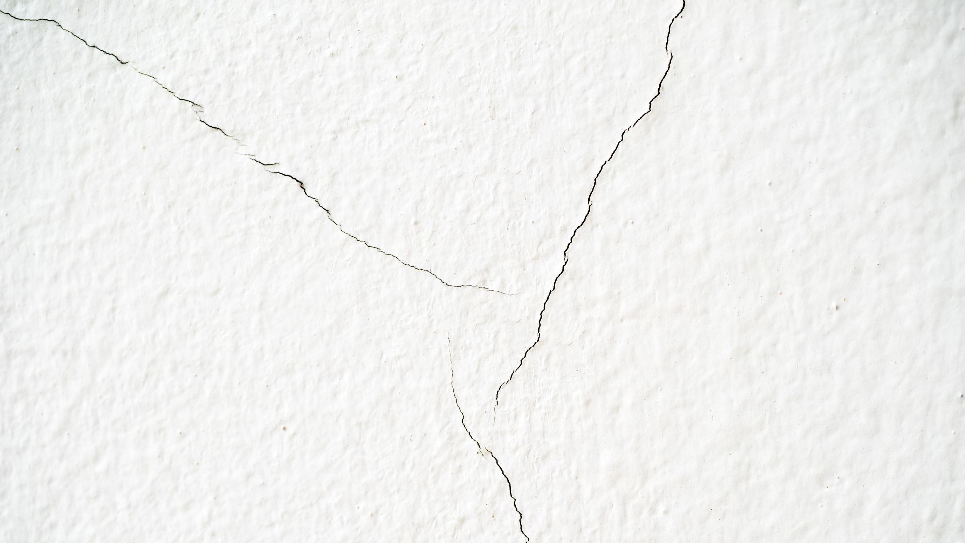 Crepa superficiale su muro intonacato, esempio comune di fessurazione non strutturale.